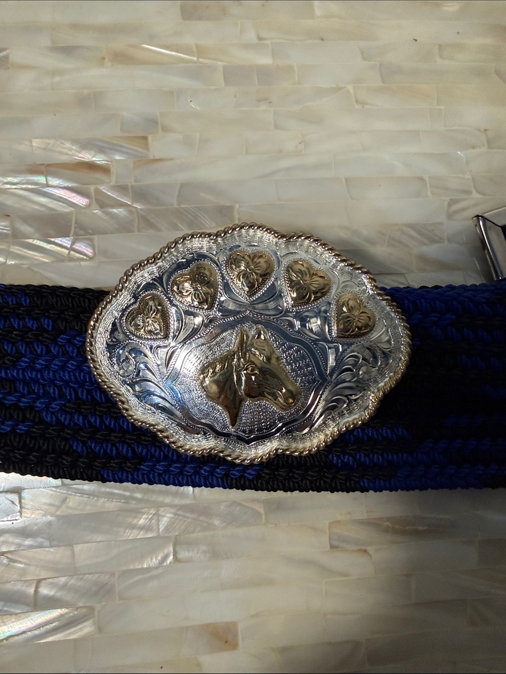Justin silver with gold accent belt buckle with black and blue belt